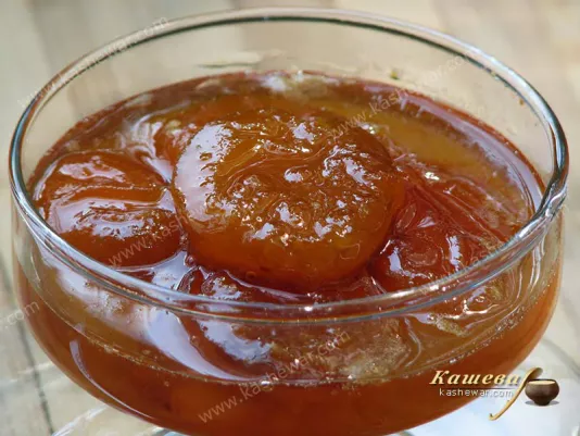 A jar of apricot jam with whole juicy slices