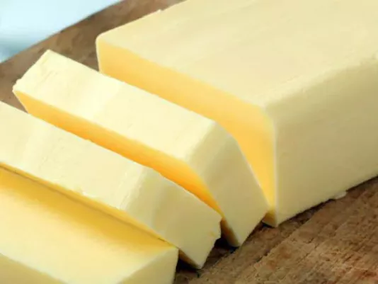 A piece of butter on a wooden board