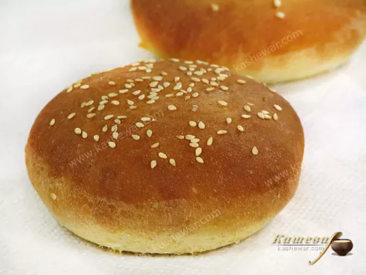 Freshly baked round hamburger bun with sesame seeds on top