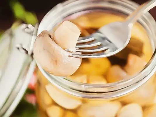 Банка з маринованими печерицями крупним планом