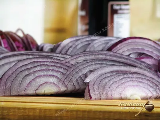 Red onion rings on a wooden cutting board