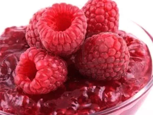 Jar of homemade raspberry jam with berries