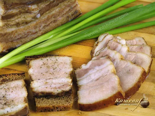 Копчена свиняча грудинка на кухонній дошці