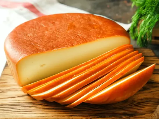 Aromatic smoked Gouda cheese on a wooden board