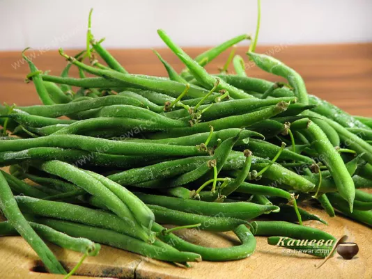 Bright green beans on a wooden board