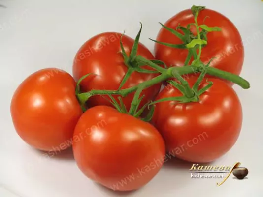 Fresh ripe tomatoes on the vine on a kitchen table