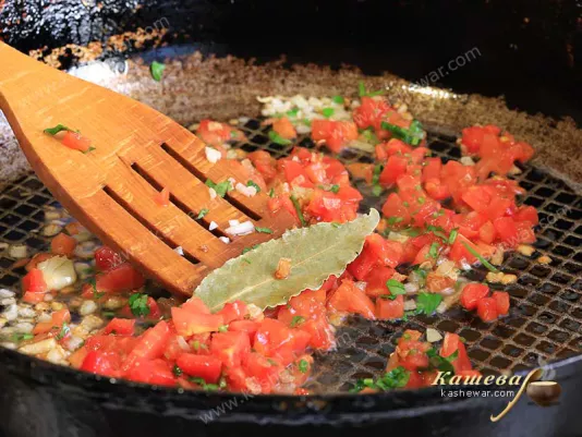 Onions and tomatoes are fried with bay leaves