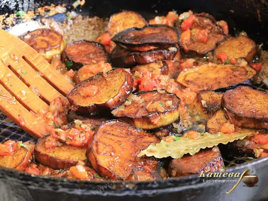 Eggplant in a frying pan with tomatoes