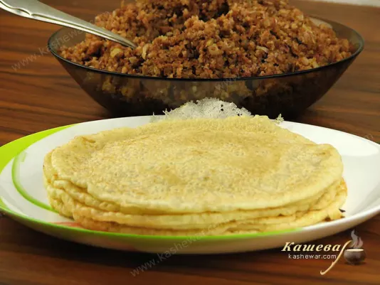 Stuffing chopped meat on pancakes and wrap