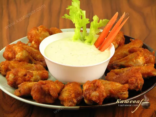 Buffalo chicken wings with sauce, celery and carrots