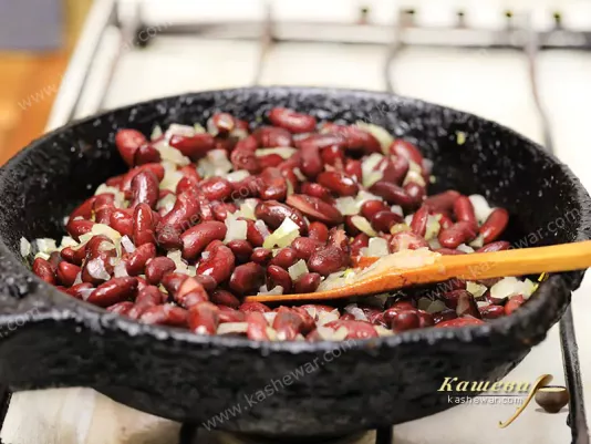 Beans with onions in a frying pan