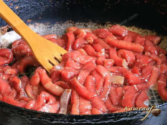 Beef, cut into strips, in a frying pan