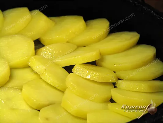 Putting potatoes in a baking dish