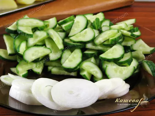 Нарезанные лук и огурцы