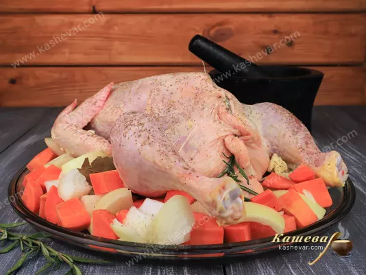 Stuffed chicken and vegetables on a baking sheet