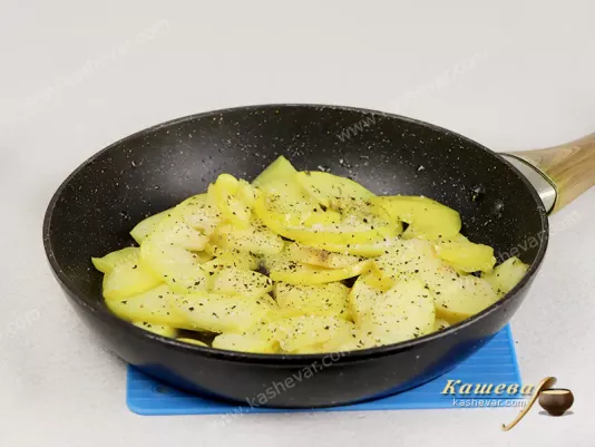 Apples fried in a frying pan in butter