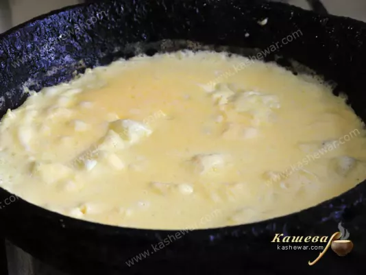 Semi-cooked omelet in a frying pan
