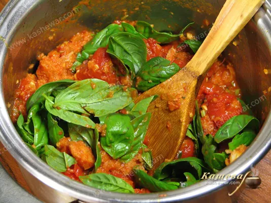 Adding basil leaves and olive oil