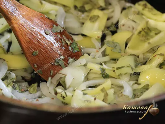 Bell peppers, onions and curry leaves in a frying pan