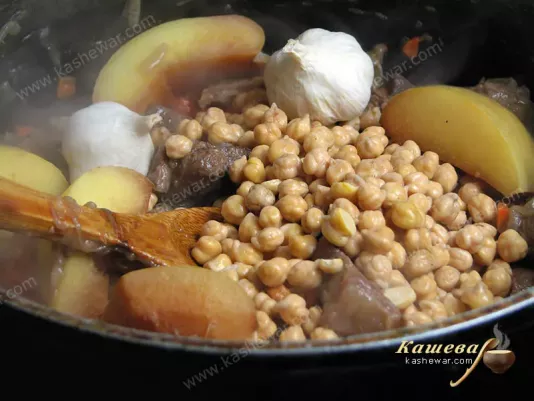 Next to the carrots, add quince, chickpea and garlic to the pilaf