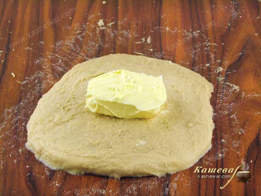 Flatten the dough into a rectangle and put butter in the center
