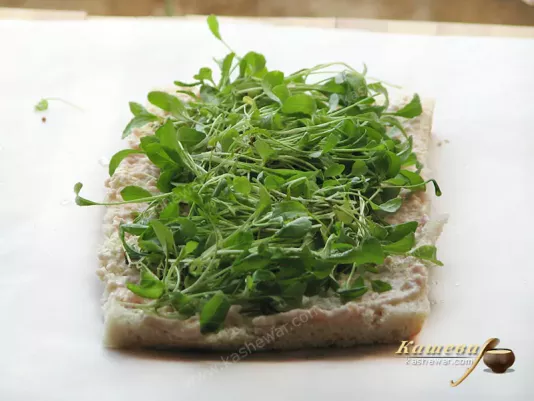 Putting the arugula on the roll