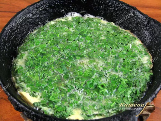 Pour eggs with herbs into a heated pan with oil